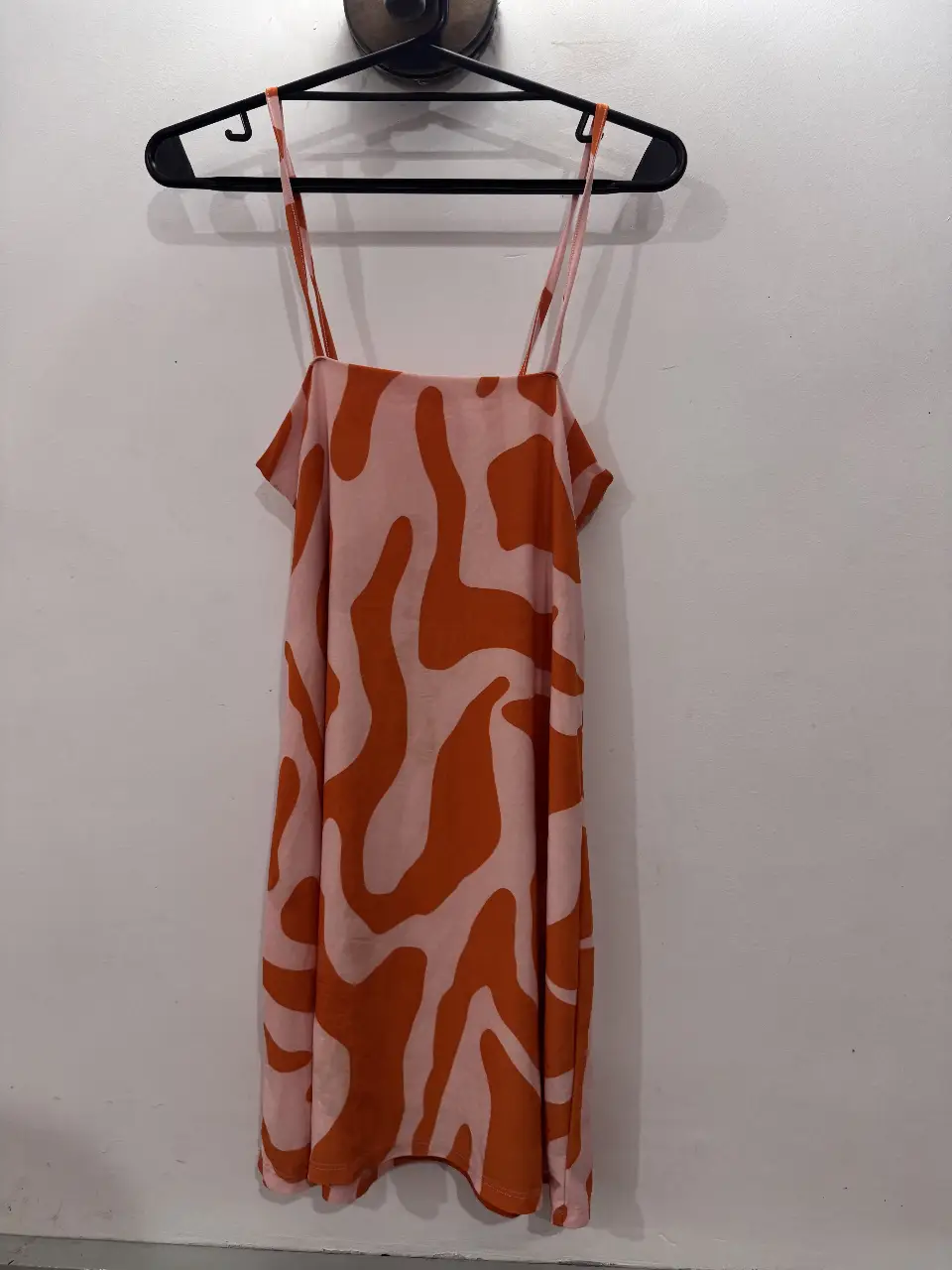 Vestido mini con estampado abstracto en tonos rosa y naranja. Ideal para un look fresco y moderno.