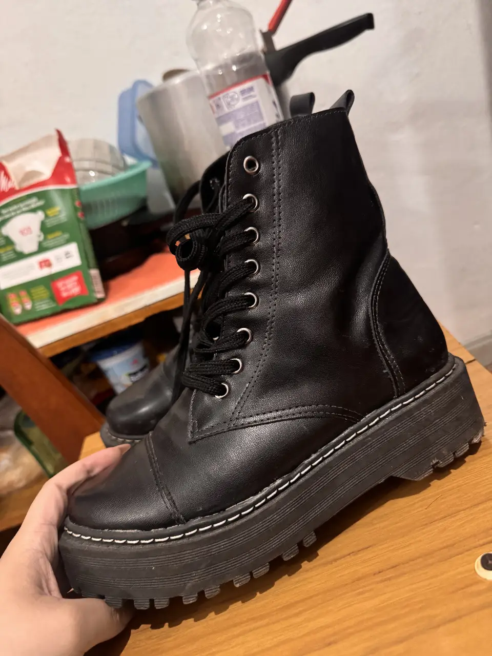Borcegos negros con plataforma, ideales para un look urbano y moderno. Con cordones y detalles de costura blanca, perfectos para combinar con cualquier outfit.