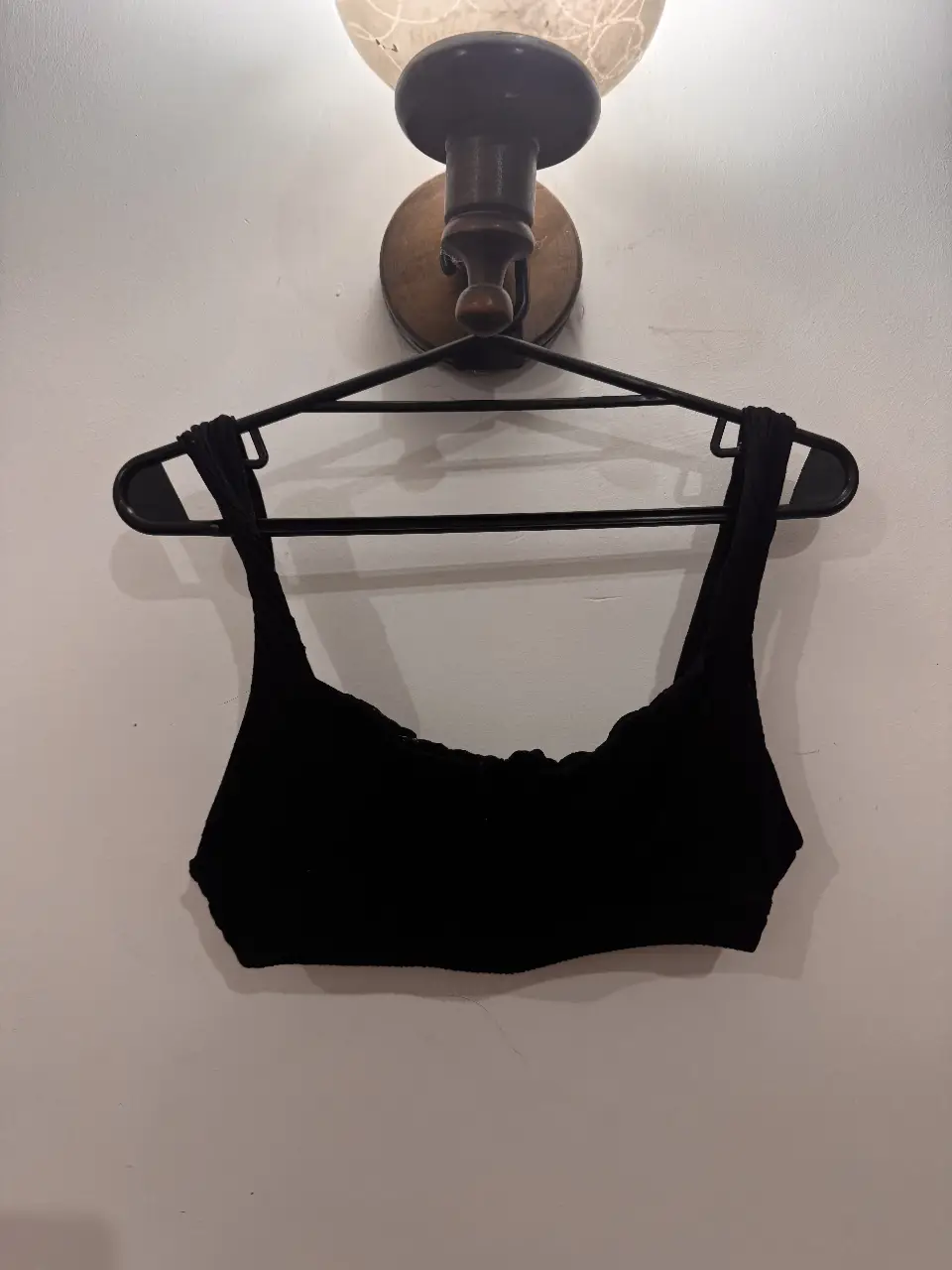Top deportivo negro, con breteles anchos y diseño fruncido en el busto. Ideal para actividades de bajo impacto o para un look casual.
