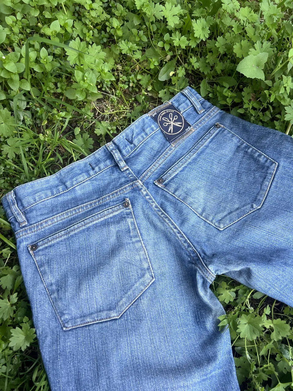 Jeans rectos de mujer ONA SAEZ JEANS, talle 37. Diseño clásico de tiro medio, con detalle de parche de la marca en el bolsillo trasero. Ideal para un look casual y versátil.