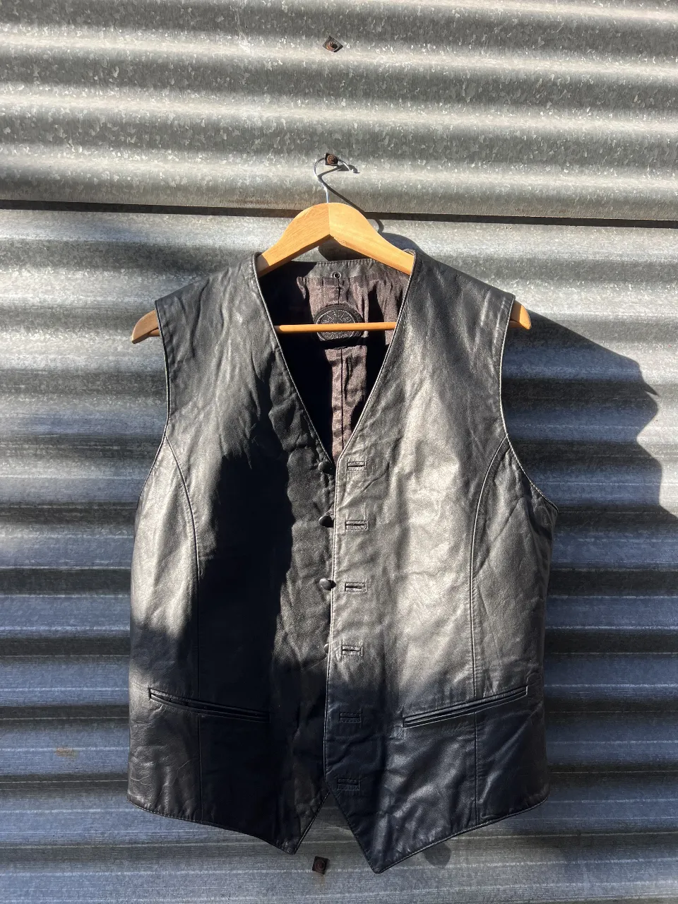 Chaleco de cuero negro unisex con botones y bolsillos. Ideal para un look rocker o casual.