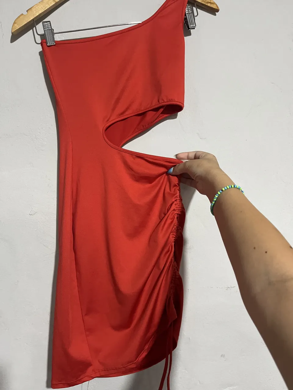 Vestido rojo súper canchero, ideal para una salida nocturna o una fiesta. Tiene un diseño asimétrico con un solo hombro y un detalle de fruncido con cordón ajustable en el lateral, que le da un toque súper sexy y moderno. ¡No te lo pierdas!