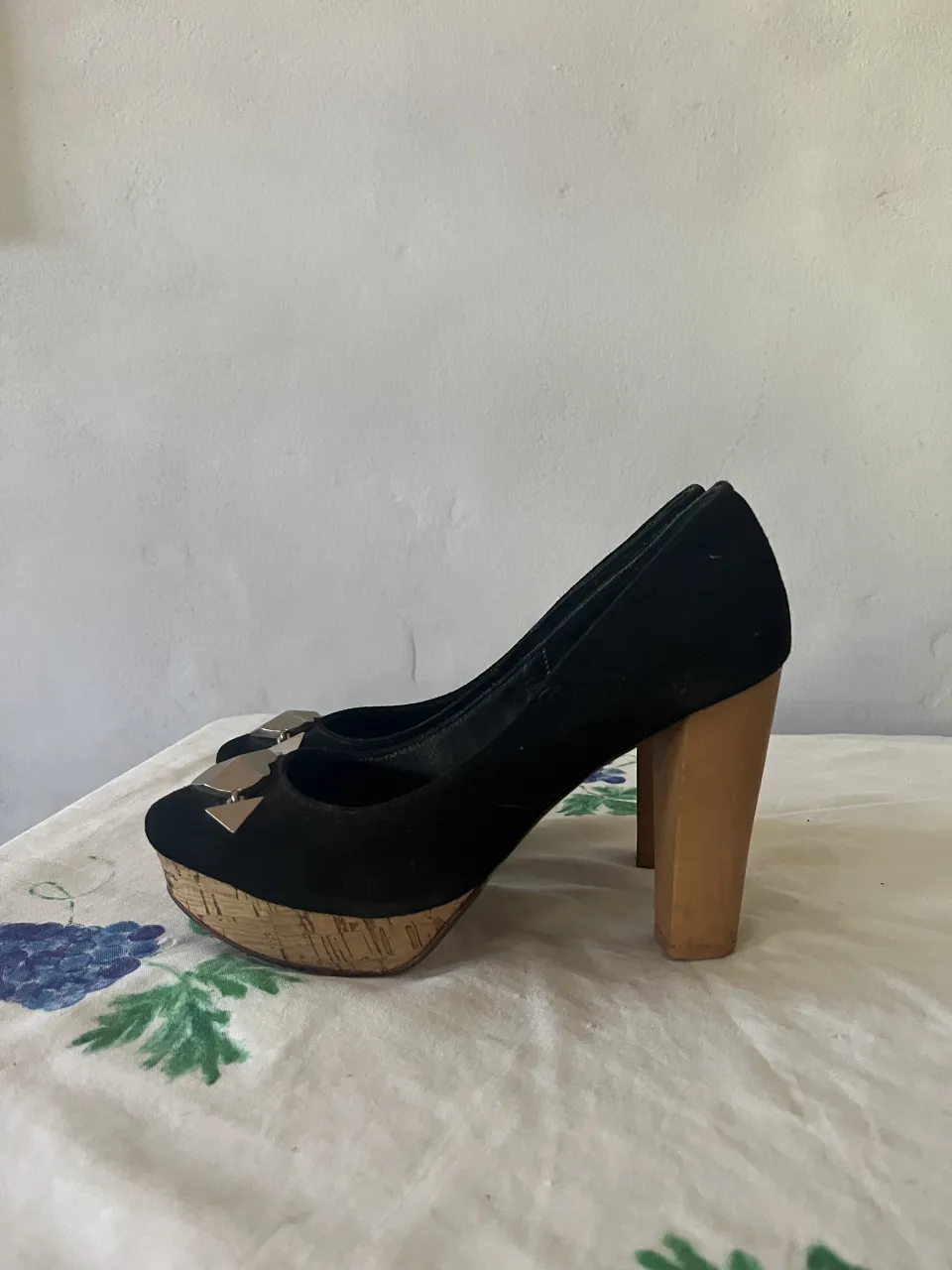 Zapatos de taco alto negros, con plataforma y detalle metálico en la punta. Ideales para un look elegante y moderno.