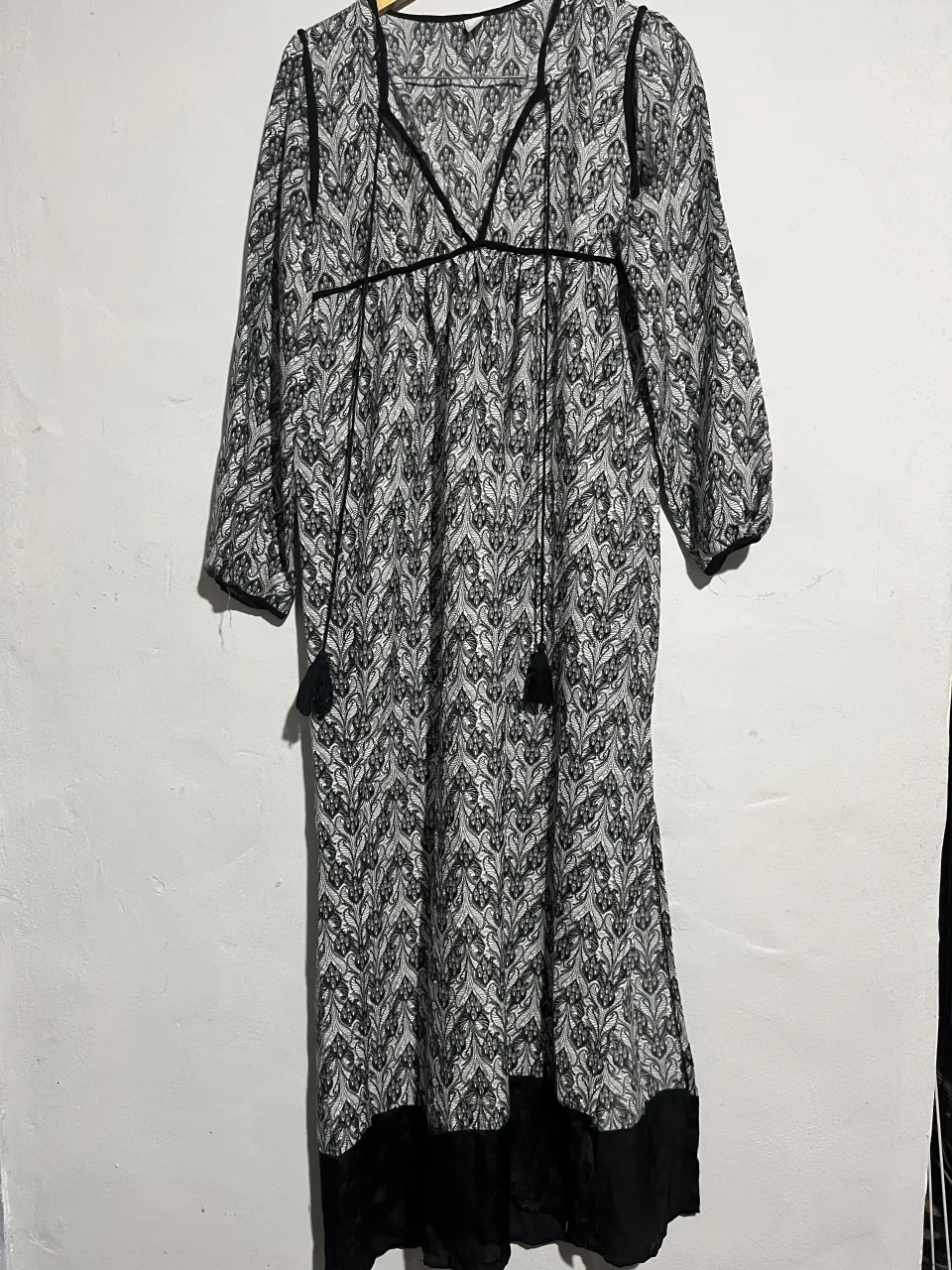 Vestido largo estampado con detalles de flecos y escote en V. Ideal para un look boho chic o casual.