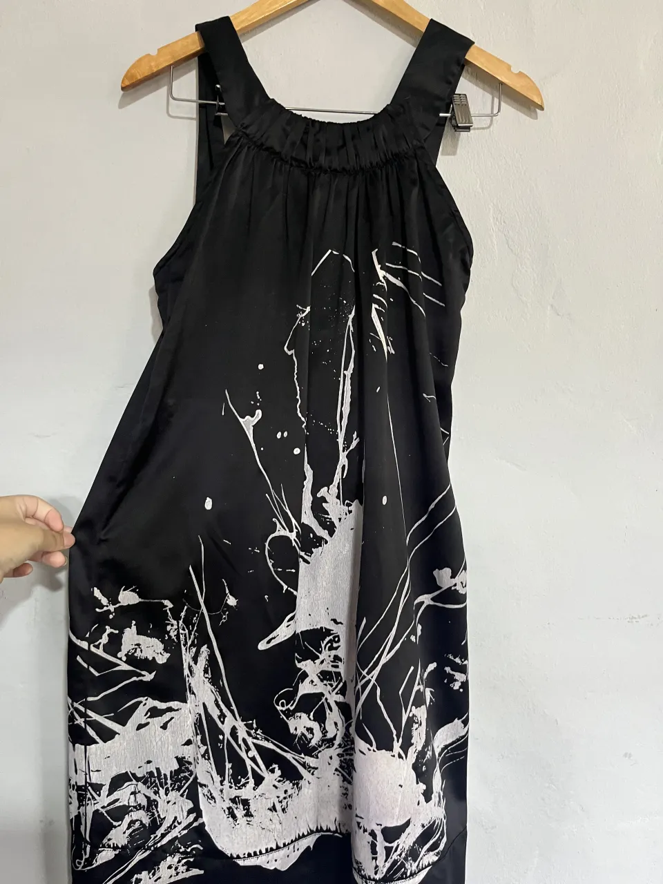 Vestido negro con estampa abstracta en blanco. Breteles finos y cuello con fruncido. Espalda con lazo para atar. Ideal para un look moderno y artístico.
