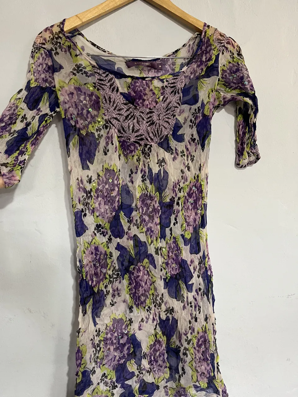 Vestido estampado floral con detalles de lentejuelas y bordado en el cuello. Ideal para un look boho chic o casual.