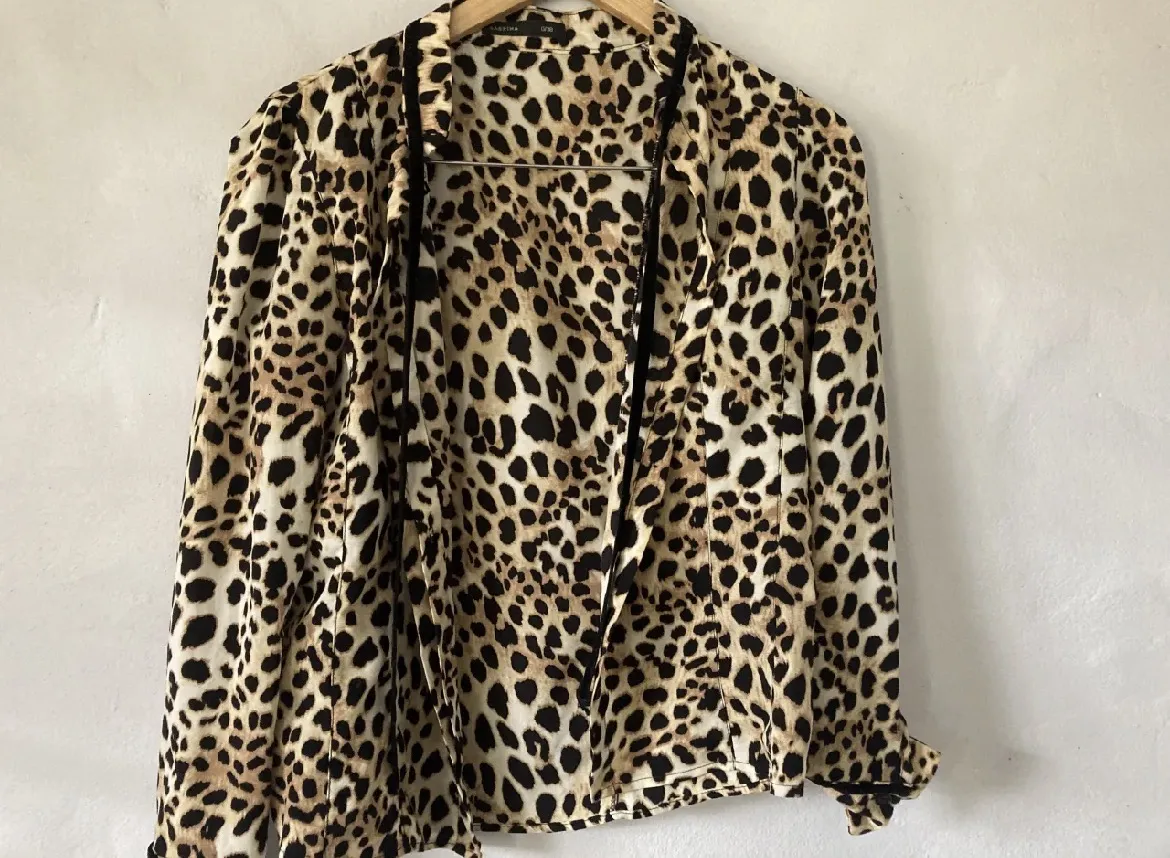 Camisa estampada con motivo de leopardo. Posee cuello camisero y mangas largas. Ideal para un look canchero y audaz.