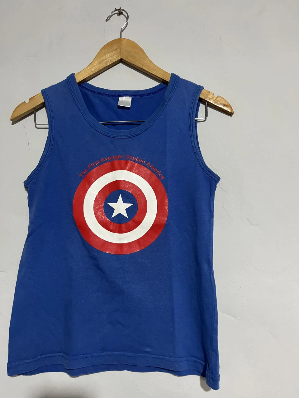 Musculosa azul de Captain America, ideal para fans de Marvel. Estampado del escudo en el frente y el rostro del personaje en la espalda. Perfecta para un look casual y divertido.
