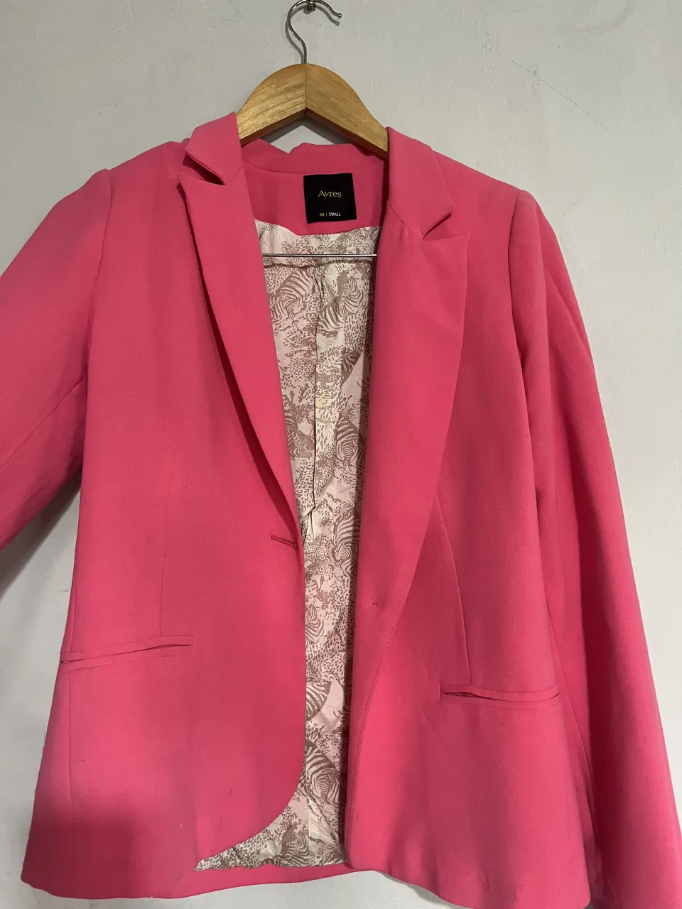 Blazer rosa vibrante con un forro interior estampado de cebras y motivos animales. Un toque de color y estilo para elevar cualquier outfit. Ideal para un look canchero y moderno.