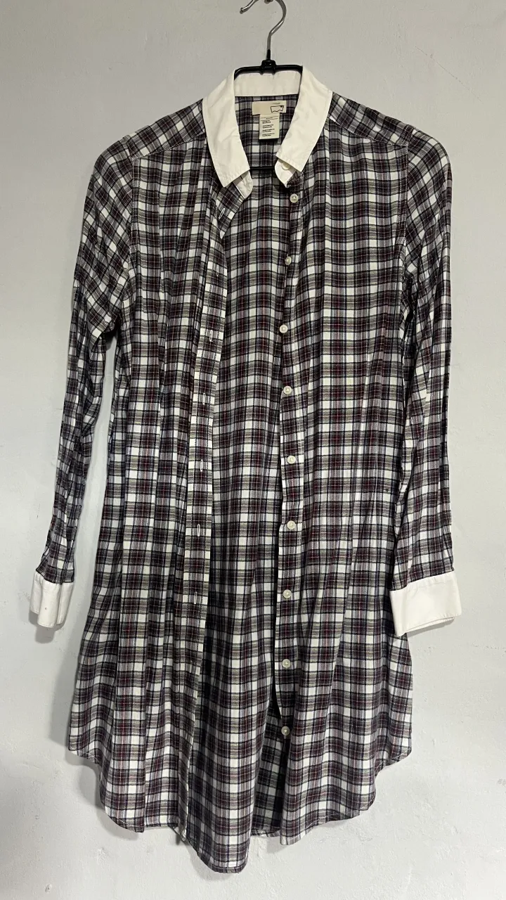 Camisa a cuadros larga, ideal para usar abierta o cerrada. Con cuello blanco y puños blancos que le dan un toque de contraste. Perfecta para un look casual y moderno.