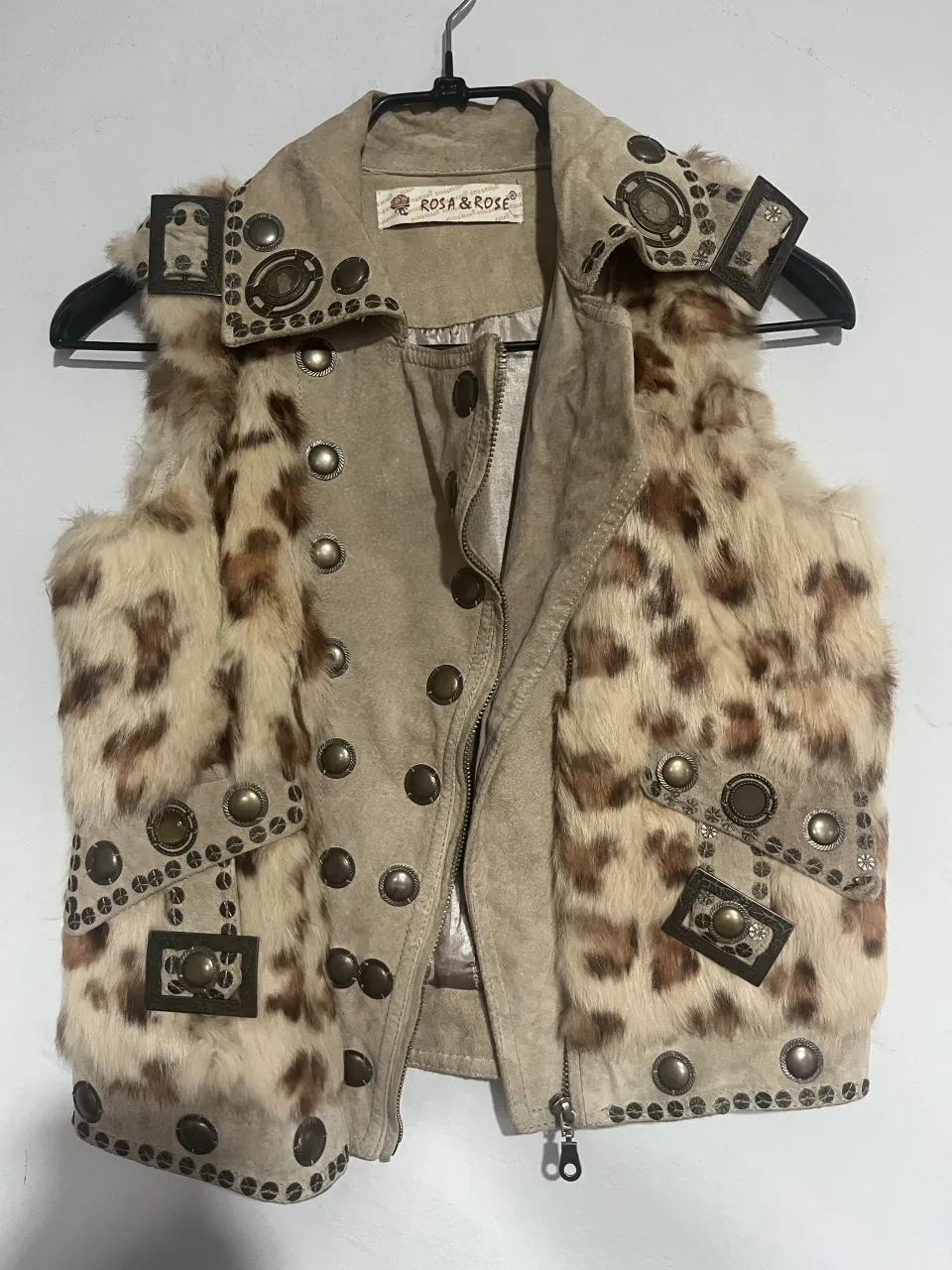 Chaleco de cuero con estampado de leopardo y detalles de tachas y hebillas. Ideal para un look rocker o boho chic.