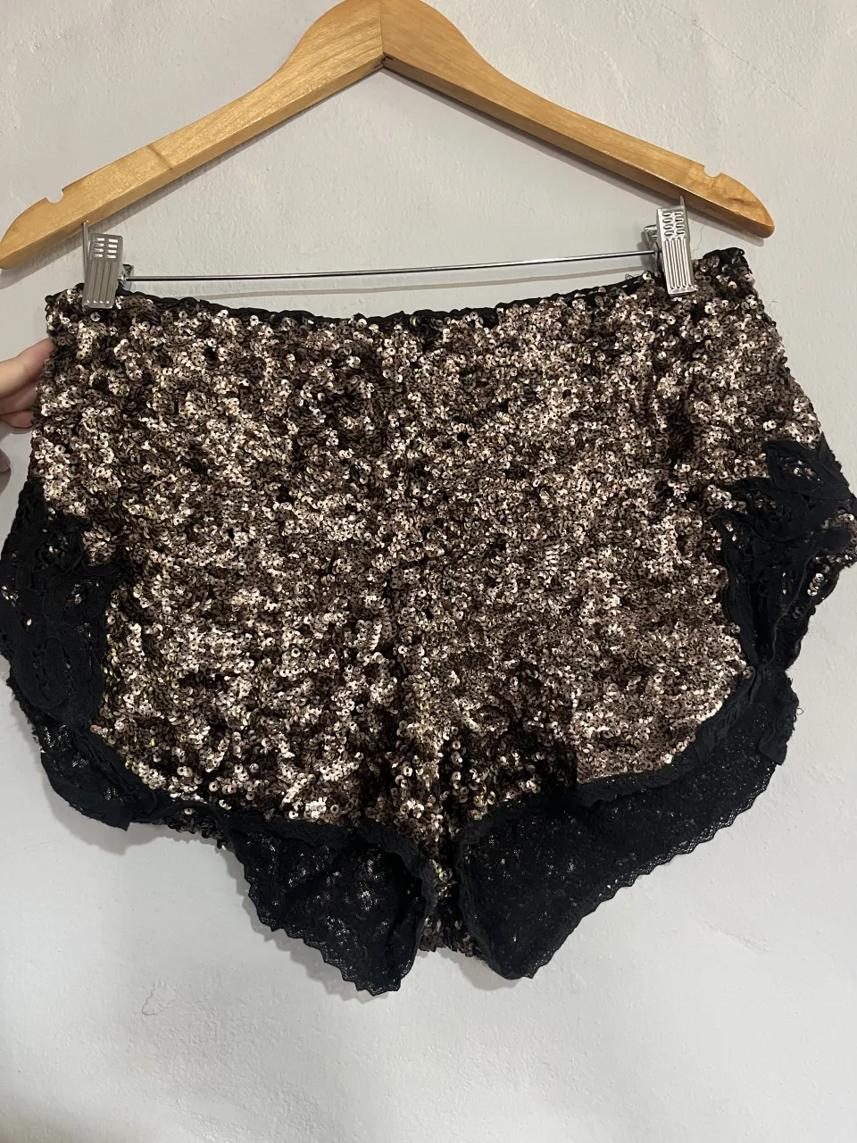 Shorts de fiesta con lentejuelas doradas y negras, detalles de encaje negro en los bordes. Cintura elastizada. Ideales para lucir en una noche especial.