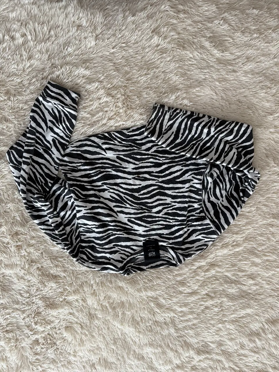 Remera manga larga con estampado de cebra. Cuello alto. Ideal para un look moderno y audaz.