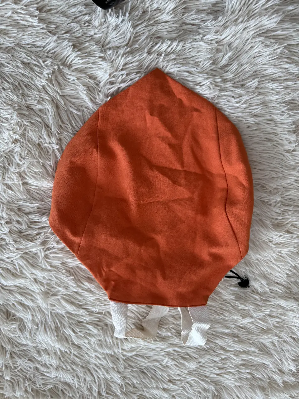 Top naranja con detalles blancos y ajuste con cordón. 