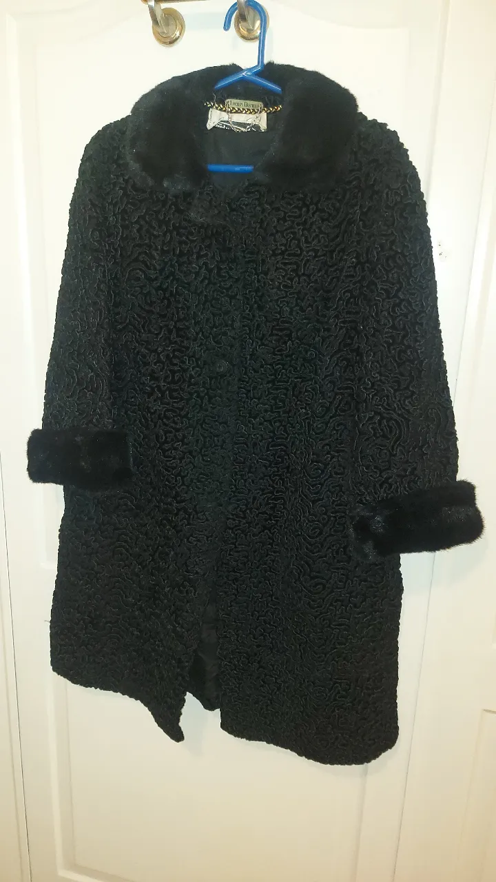 Abrigo VINTAGE,  de piel sintética negro, con cuello y puños de pelo. Diseño elegante y sofisticado, ideal para eventos especiales o para darle un toque de glamour a tu look invernal. Cierre frontal y forro interior.