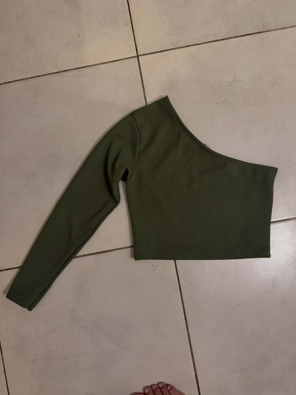 Remera manga larga asimétrica de color verde oscuro.