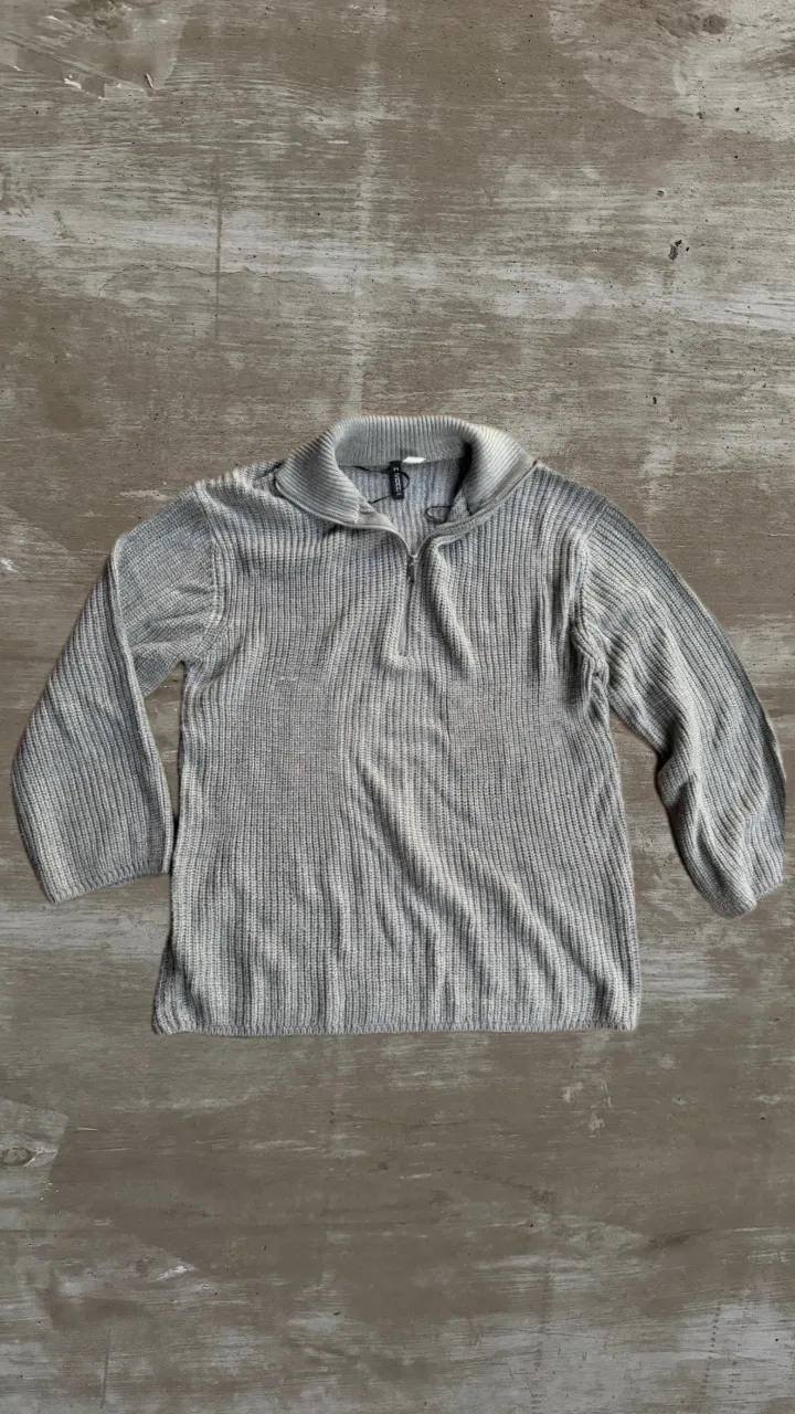 Sweater de tejido de punto con cuello y cierre.