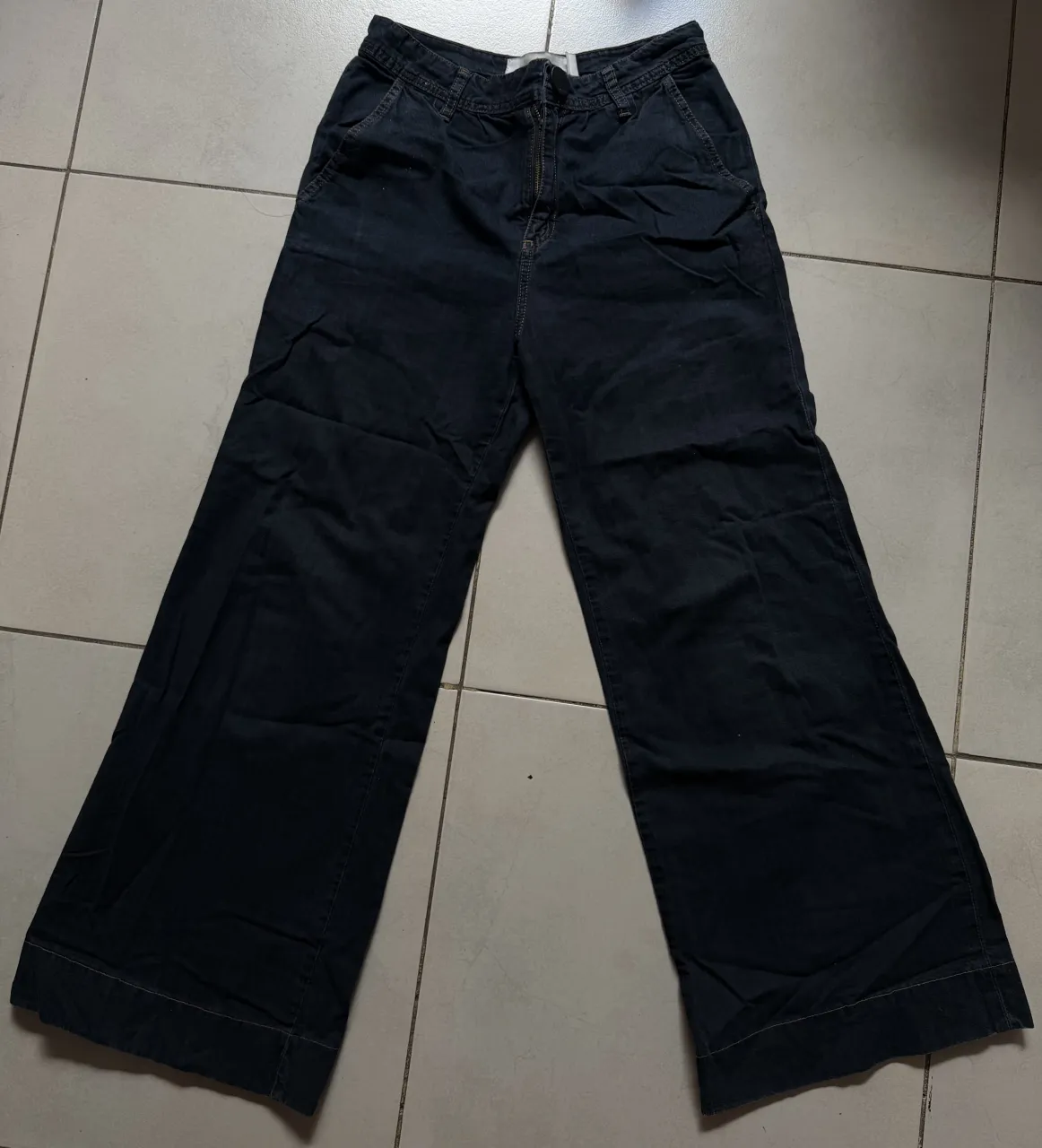 Pantalón de Ginebra ancho de gabardina color azul oscuro. Cierre y botón en la cintura. Bolsillos delanteros y traseros.