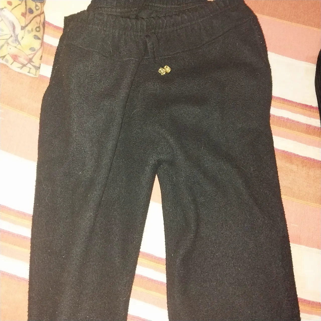 Pantalón de tela negro con detalle dorado en la cintura. Se vende con dos pantalones de pana negros y azul marino.