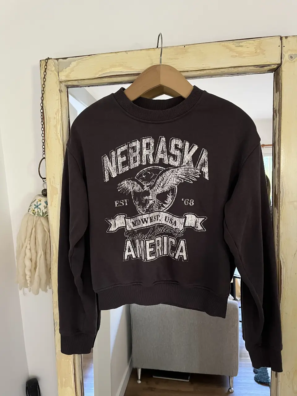 Buzo de H&M cuello redondo negro con estampado "Nebraska" en blanco. Estilo vintage con diseño de águila y detalles de "Midwest, USA". Ideal para un look casual y urbano.