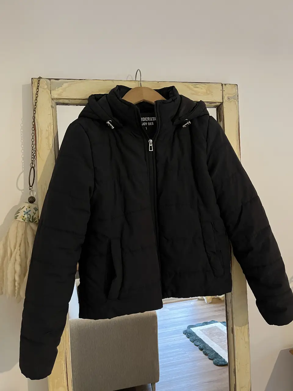 Campera negra acolchada, impermeable con capucha, ideal para el invierno. Cuenta con cierre frontal y bolsillos laterales. Marca: DESIDERATA.