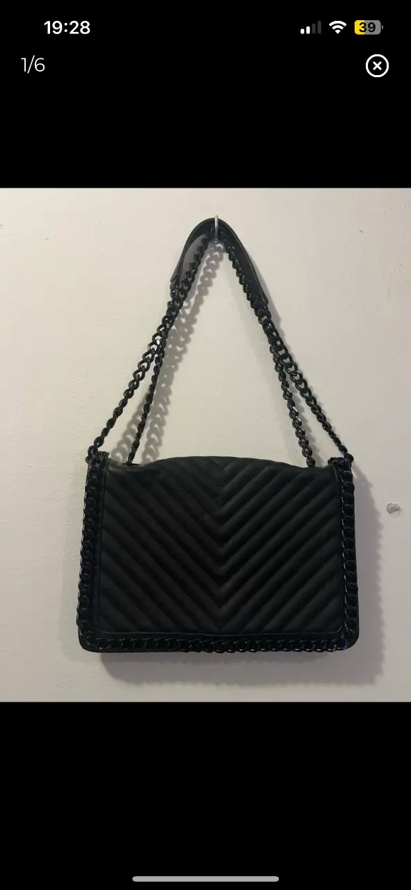 Cartera negra de hombro con cadena, estilo acolchado y diseño en zig-zag. Ideal para un look elegante y moderno. 20cm x29