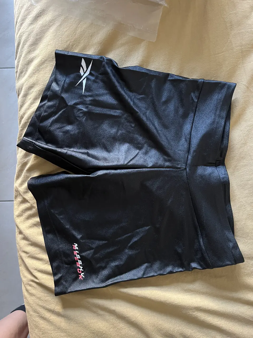 Biker negro de la marca Reebok, ideal para actividades físicas. Confeccionado en material brillante y con el logo de la marca en blanco. Talle M.