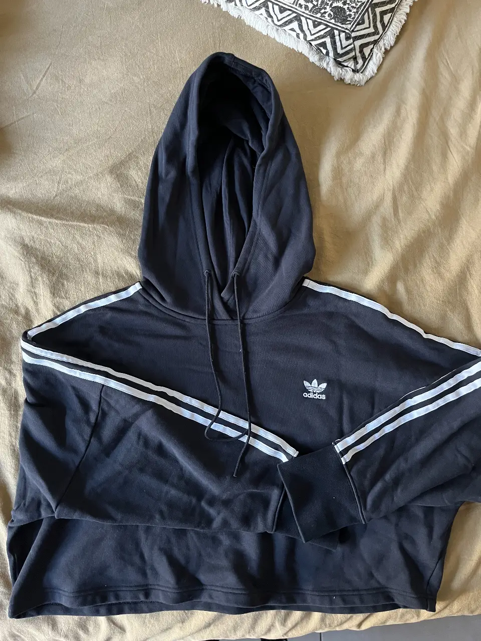 Hoodie negro con capucha y detalles blancos. Estilo deportivo, ideal para un look casual y cómodo.