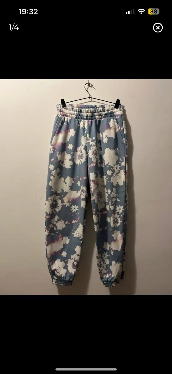 Pantalón de jogging Adidas con estampado floral en tonos azules, blancos y violetas. Talle M, ideal para un look casual y cómodo.