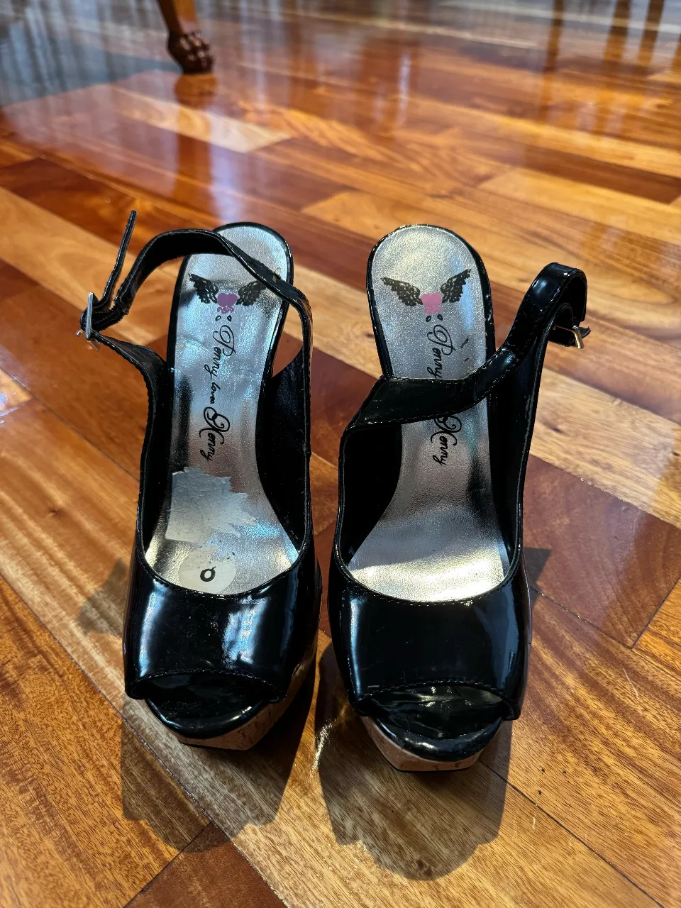 Hermosos tacos negros de charol con plataforma y detalle de madera. Ideales para una fiesta o evento especial.