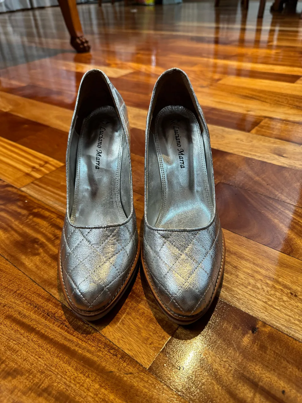 Elegantes zapatos de tacón alto plateados con diseño acolchado. Ideales para eventos formales y fiestas.