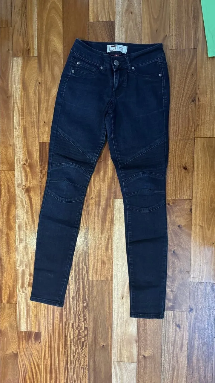 Jeans chupín de mujer, tiro alto, color azul oscuro, con detalles en las rodillas.