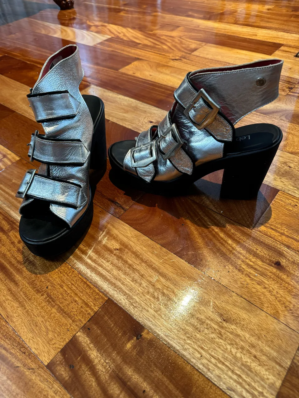 Sandalias plateadas con plataforma y hebillas, ideales para un look moderno y audaz. Perfectas para salir o para un evento especial.