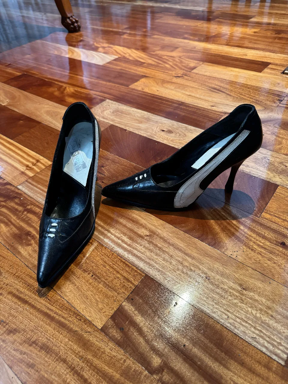 Elegantes zapatos de taco alto negros con detalles en blanco. Ideales para eventos formales o salidas nocturnas.