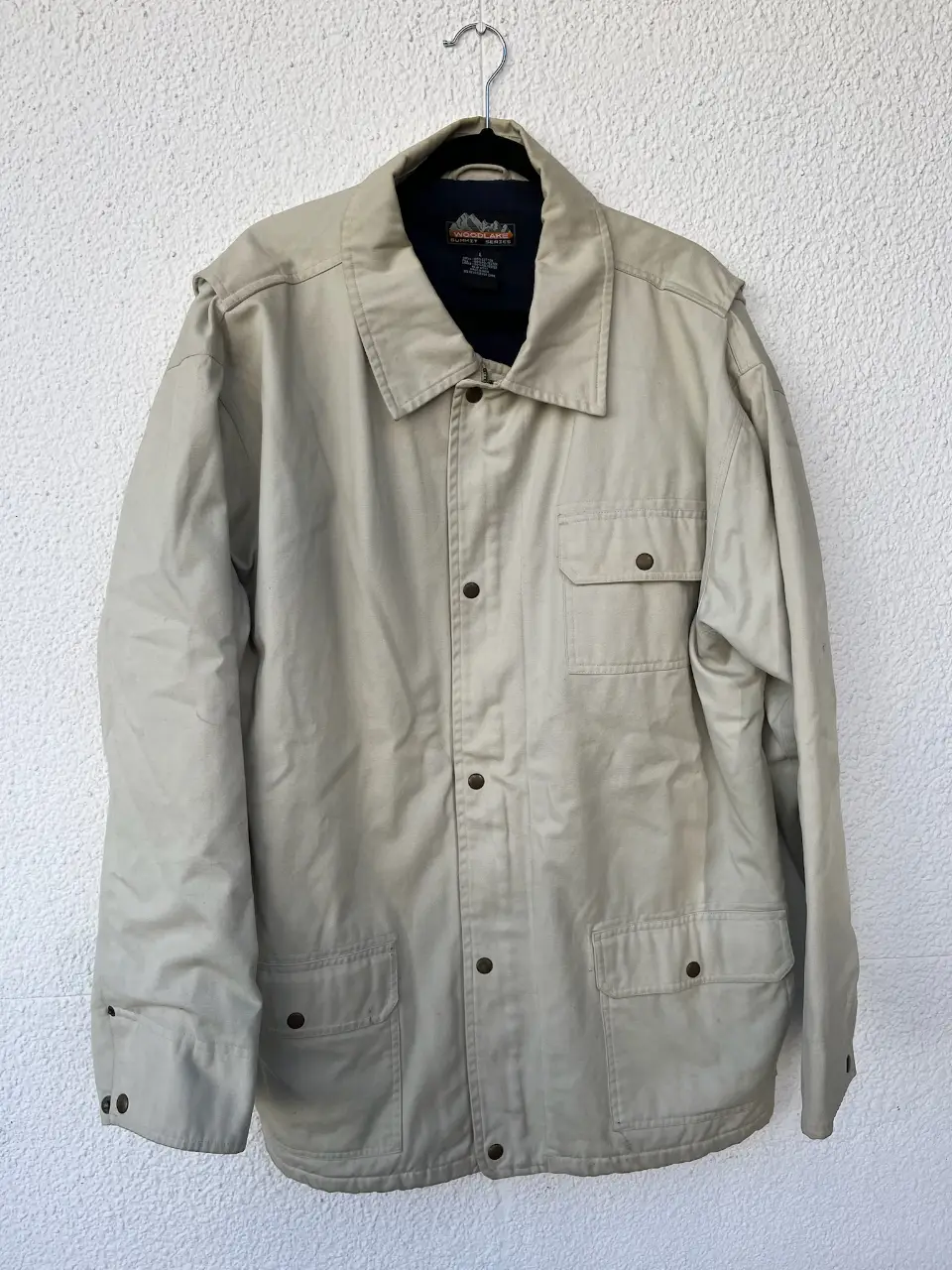 Campera de hombre color crudo, estilo utilitario. Con botones, bolsillos y cuello clásico. Ideal para un look casual y cómodo. adentro tiene polar azul 