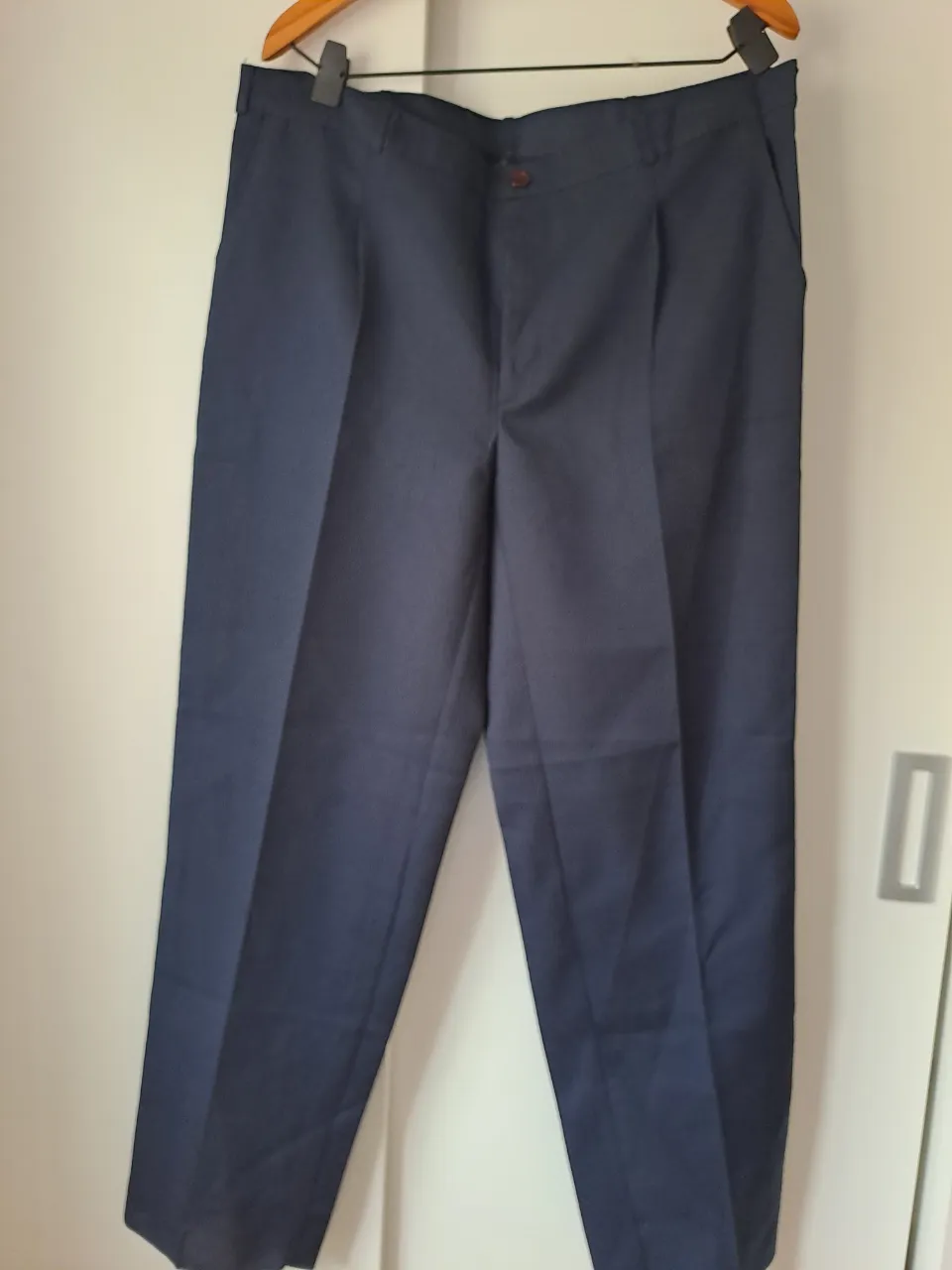 Pantalón de vestir azul marino con pinzas delanteras y bolsillos laterales. Cierre con botón y gancho.Talle 50.ideal para uniformes.Tela tropical.