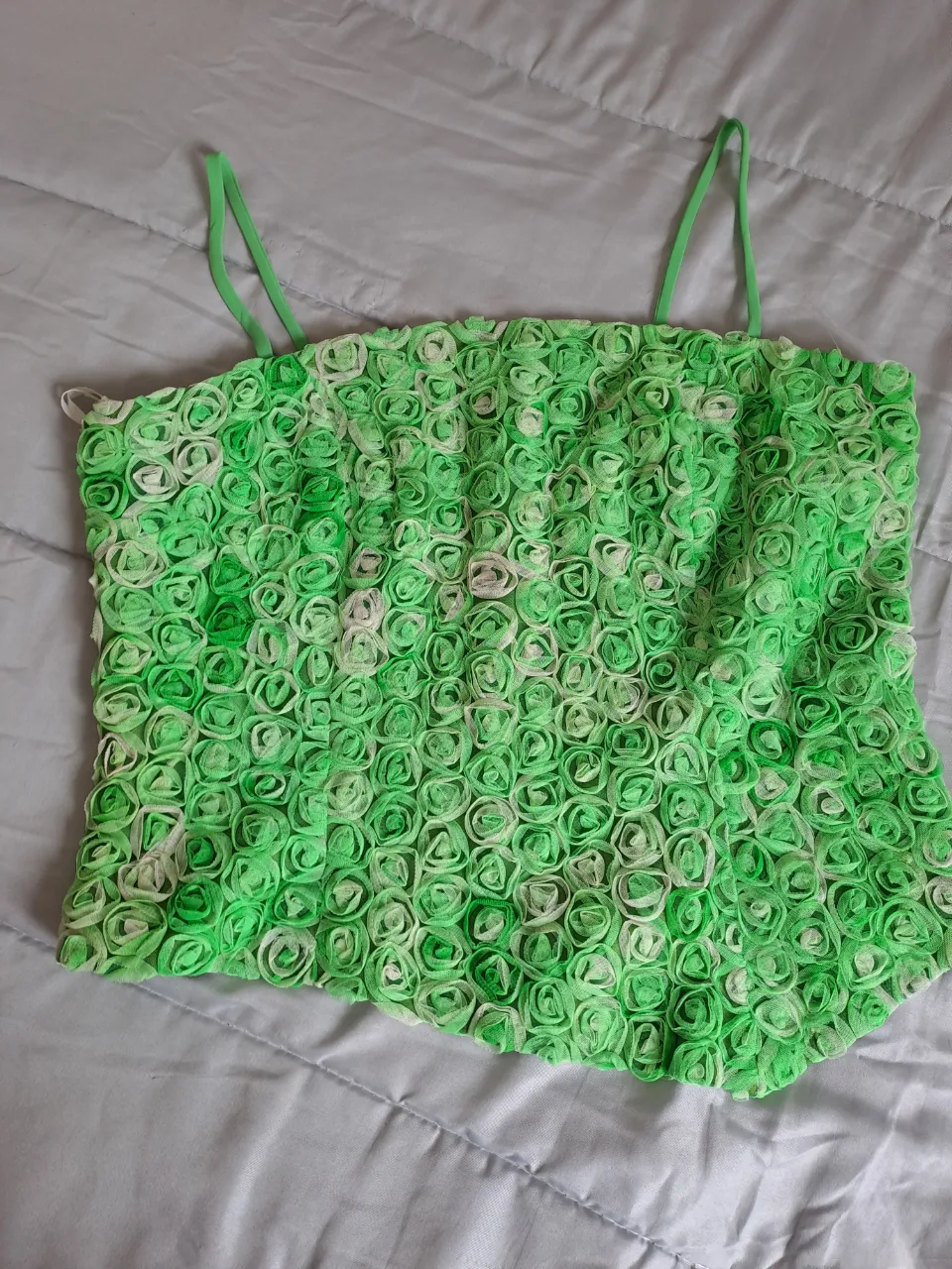 Top verde con tiras finas y textura de flores en relieve. Cierre en la espalda.