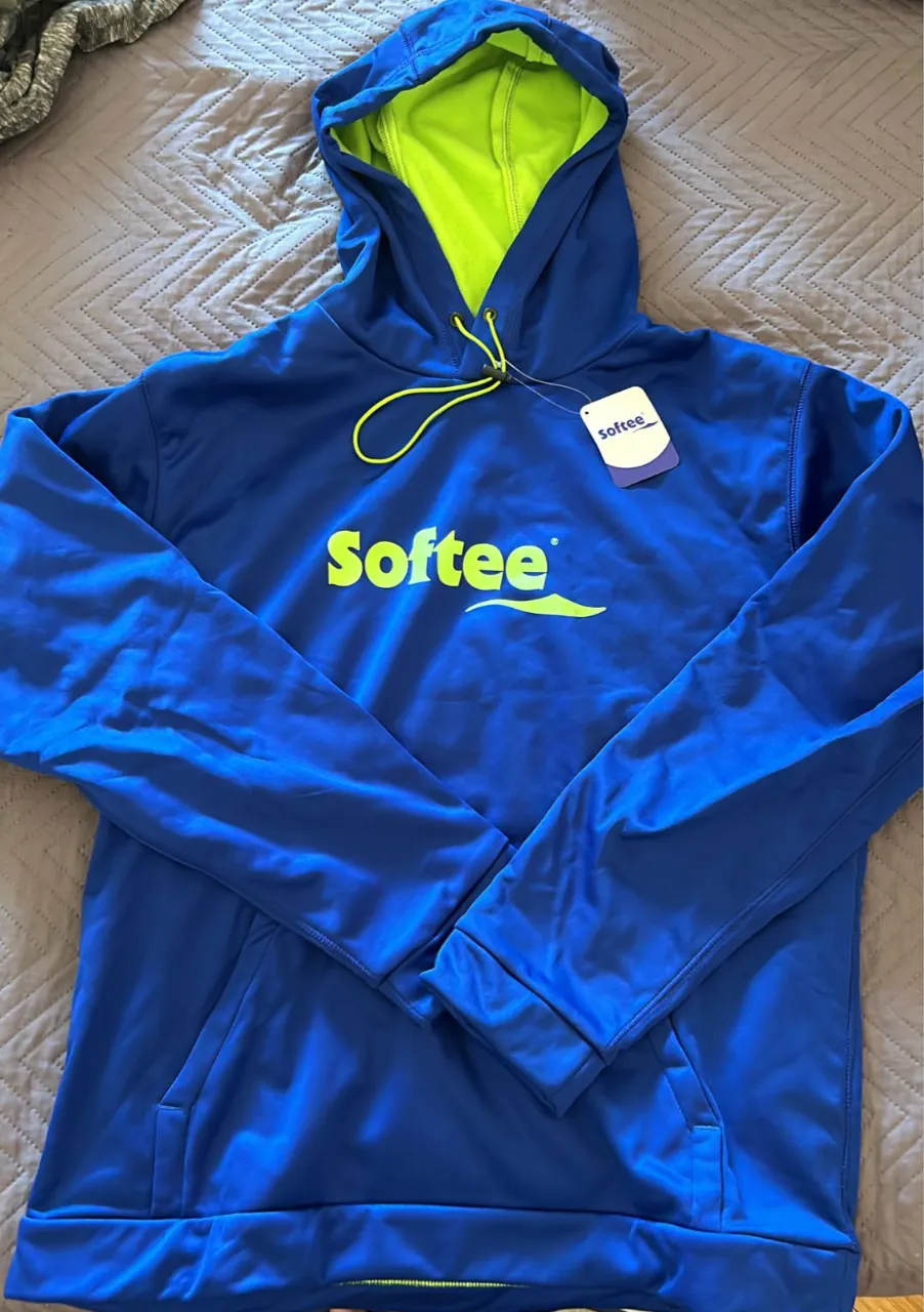 Buzo azul con capucha y cordones fluorescentes. Estampado frontal con logo de la marca "Softee" en color amarillo y verde. Bolsillo canguro en la parte delantera. NUEVO, impermeable deportivo. 