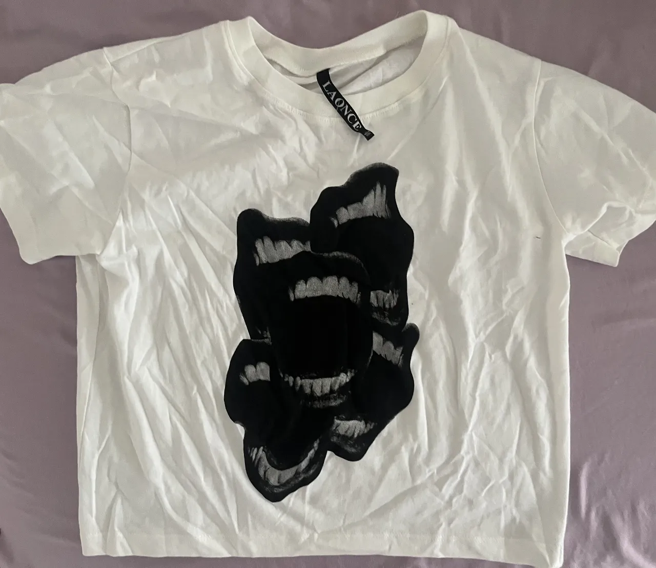 Remera blanca crop top con estampa de labios negros. Ideal para un look urbano y canchero.