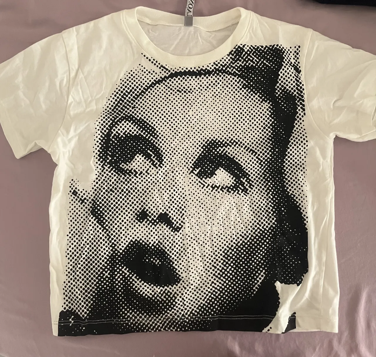 Remera blanca crop con estampa de rostro en blanco y negro. Diseño único y llamativo, ideal para un look urbano y moderno.