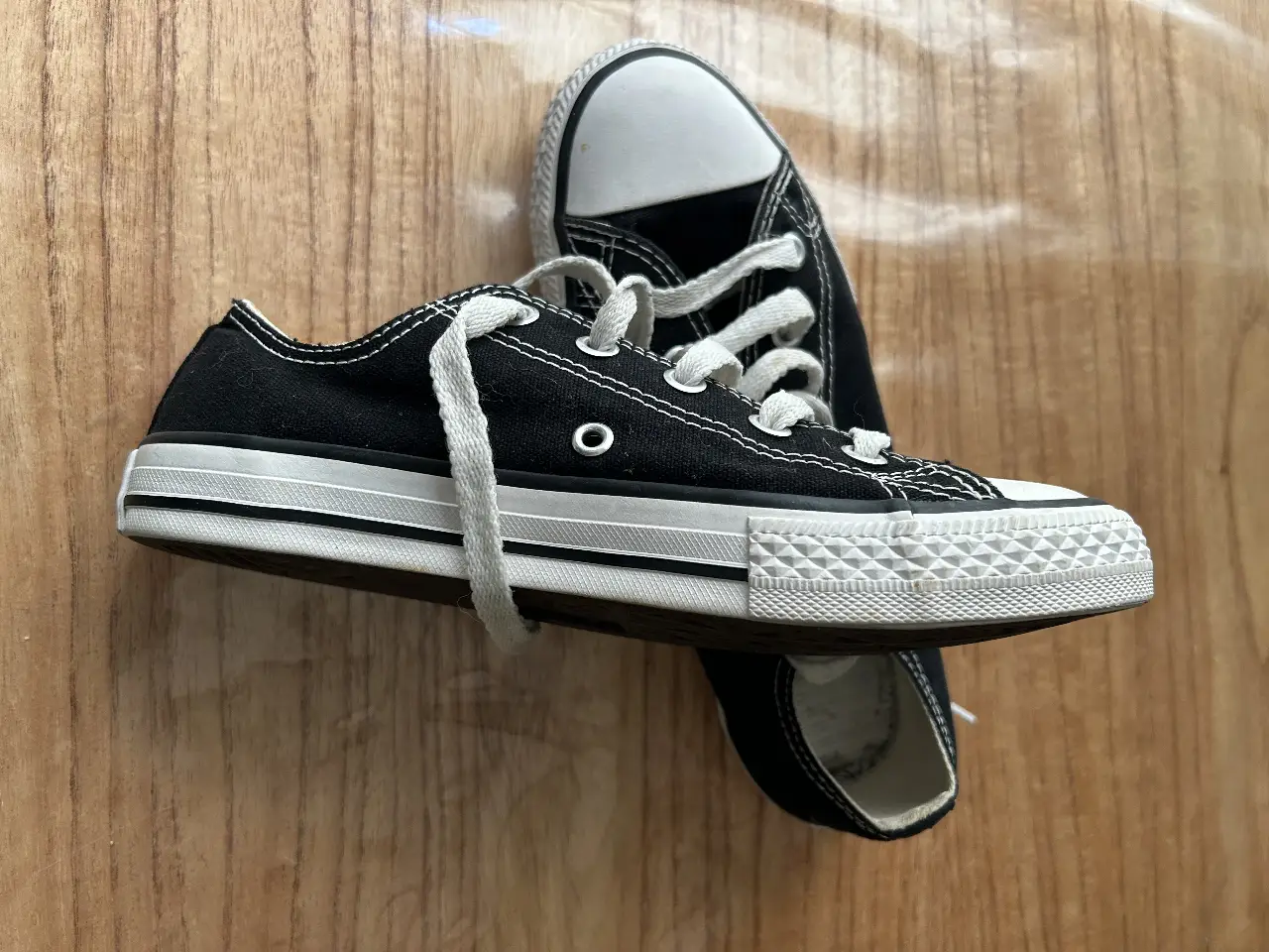 Zapatillas Converse All Star bajas en color negro con puntera blanca. Un clásico atemporal para un look casual y cómodo.