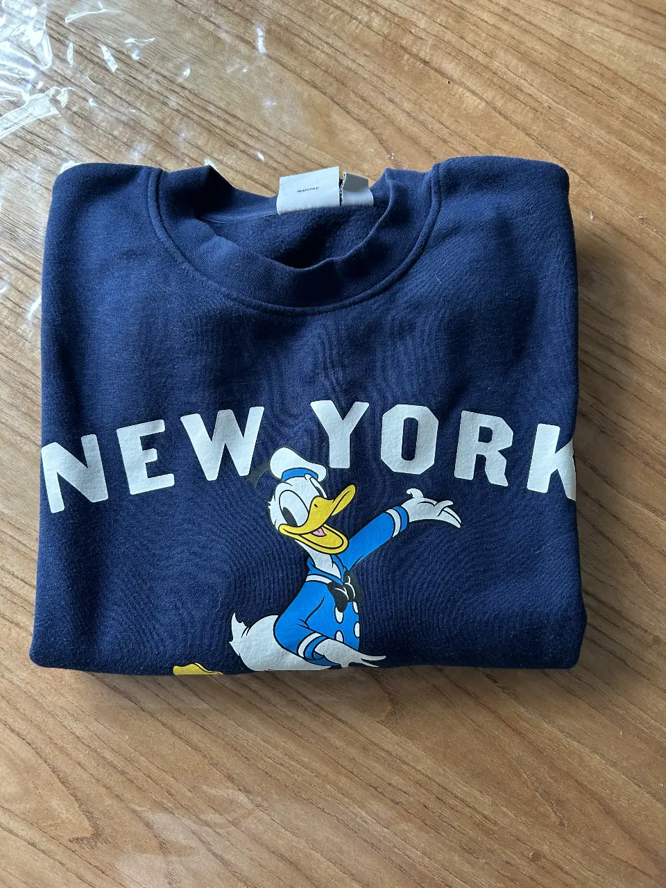 Buzo de cuello redondo azul marino con estampado de Donald Duck en el frente y la inscripción "NEW YORK". Ideal para un look casual y cómodo.