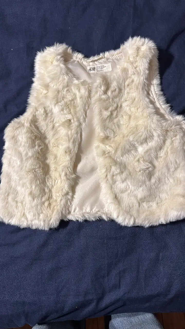 Chaleco de piel sintética color crema, ideal para agregar un toque de elegancia y abrigo a cualquier outfit. Perfecto para combinar con diferentes estilos y ocasiones.