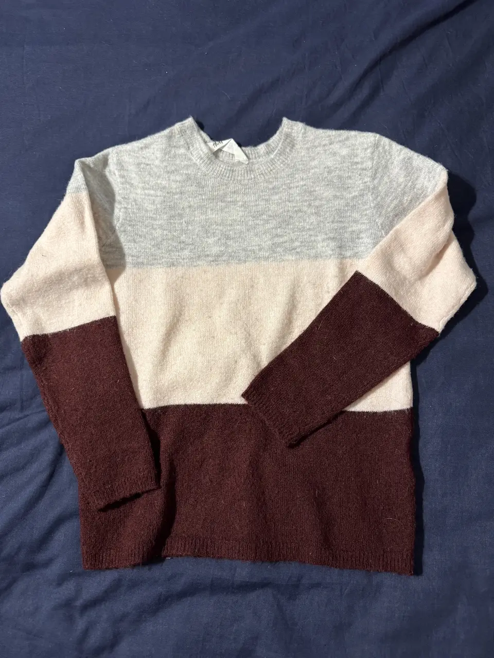 Sweater de lana a rayas horizontales en tonos gris, blanco y marrón. Ideal para un look casual y abrigado.