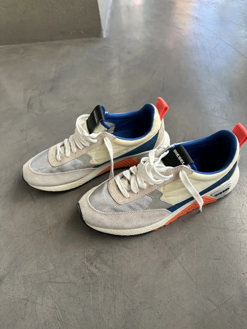 Zapatillas Diesel S-KB Low Lace II para hombre. Diseño moderno con detalles en gris, blanco y azul. Suela de goma con detalles en naranja y negro. Ideales para un look casual y urbano.