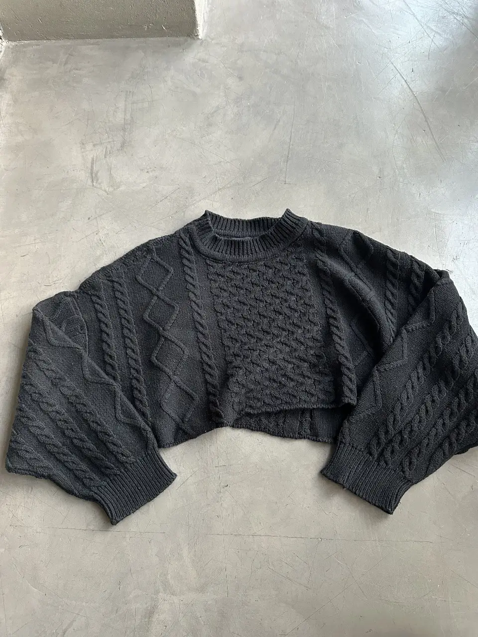 Sweater crop de tejido grueso con diseño de trenzas. Ideal para un look moderno y abrigado. 