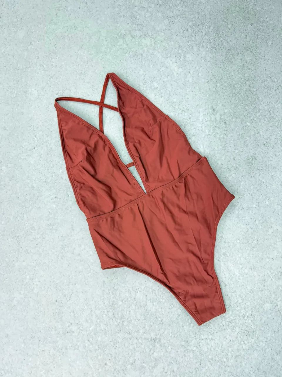 ¡Luce espectacular con este traje de baño entero! Su diseño audaz con escote profundo y tiras cruzadas en la espalda te hará destacar. Perfecto para disfrutar del sol y el mar con mucho estilo.