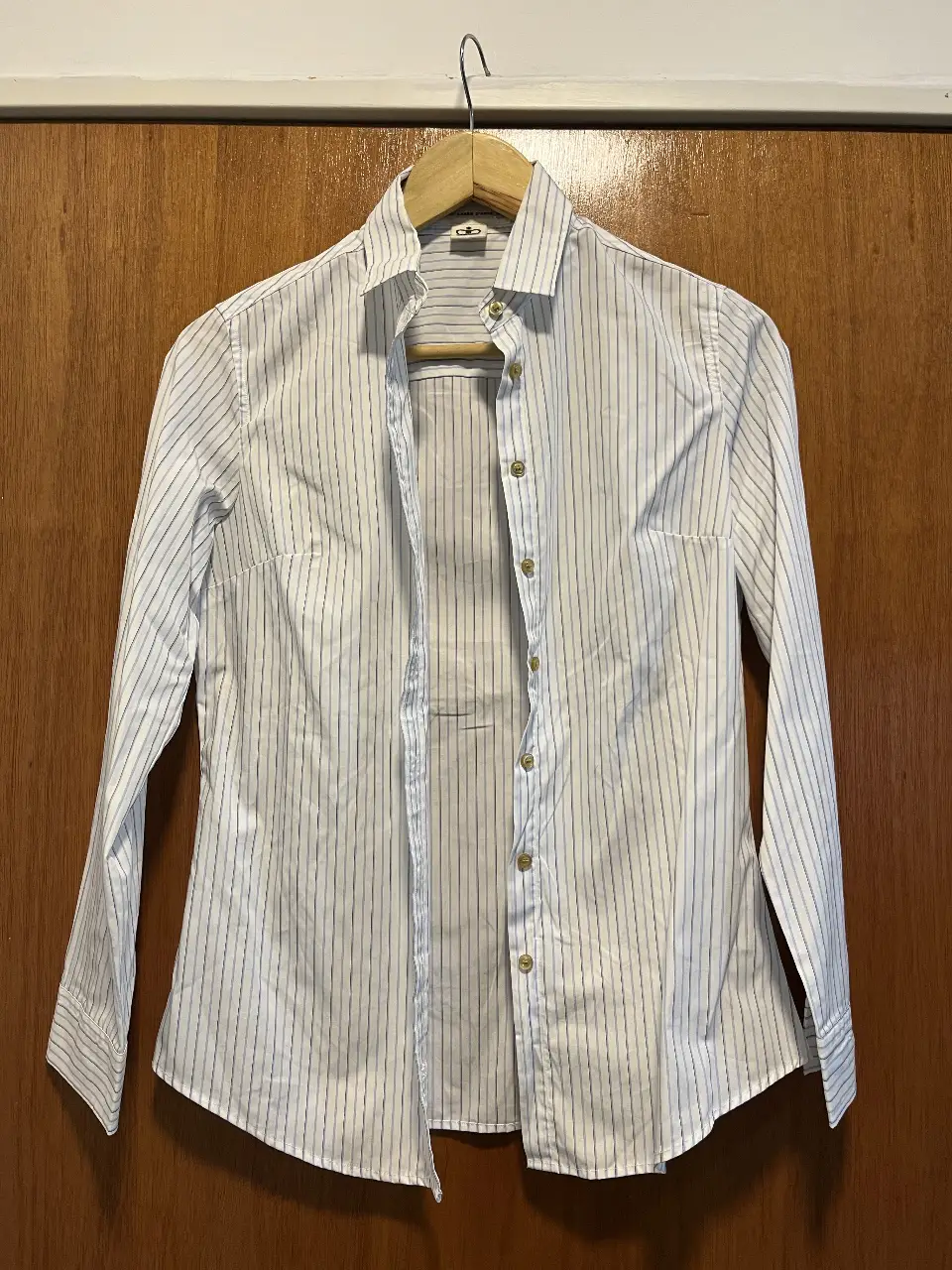 Camisa de mujer a rayas verticales en blanco y azul. Ideal para un look elegante y fresco. Perfecta para el trabajo o una salida casual.