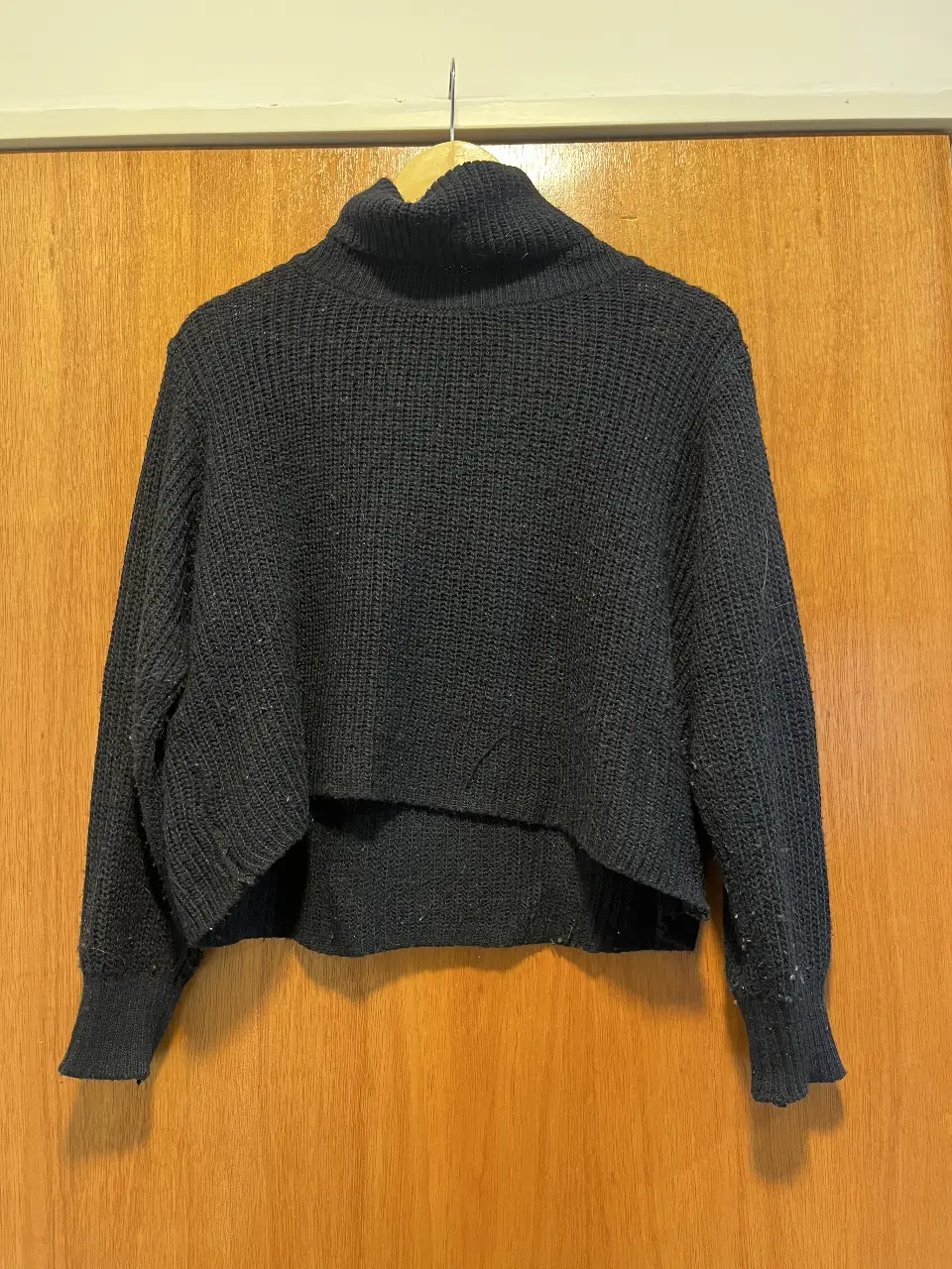 Sweater de cuello alto negro, tejido grueso, ideal para el invierno. Corte cropped, perfecto para un look casual y moderno.