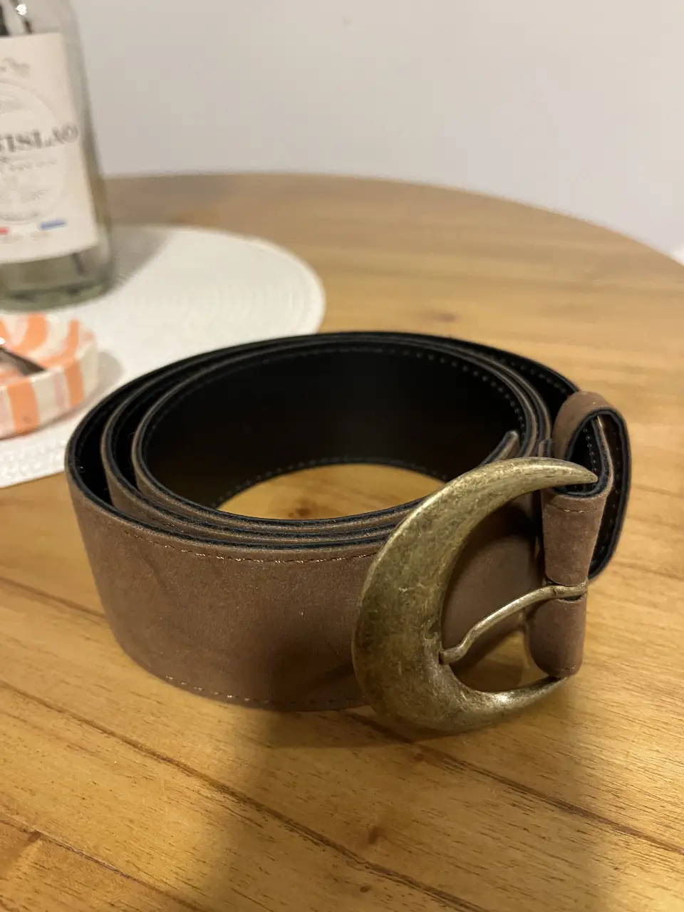 Cinturón de cuero marrón con hebilla dorada. Ideal para darle un toque de estilo a cualquier outfit.